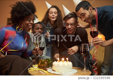 Portrait of adult man using wheelchair and blowing candles on Birthday cake with group of friends celebrating at home Portrait of adult man using wheelchair and blowing candles on Birthday cake with group of friends celebrating at home 112193590