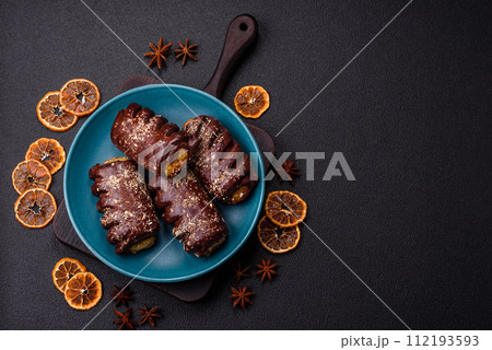 Delicious sweet chocolate cakes with fruit filling and sprinkles on a ceramic plate Delicious sweet chocolate cakes with fruit filling and sprinkles on a ceramic plate 112193593