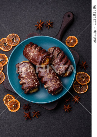 Delicious sweet chocolate cakes with fruit filling and sprinkles on a ceramic plate 112193596