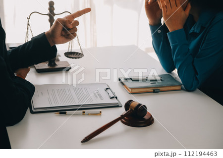 Justice and Law concept. Legal counsel presents to the client a signed contract with gavel and legal law or legal having team meeting at law firm in background 112194463