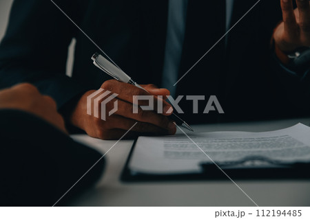 Justice and Law concept. Legal counsel presents to the client a signed contract with gavel and legal law or legal having team meeting at law firm in background 112194485