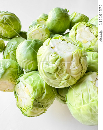 Close up of fresh green Brussels sprouts on white background. Organic vegetable, healthy food, vegan diet concept. 112194579