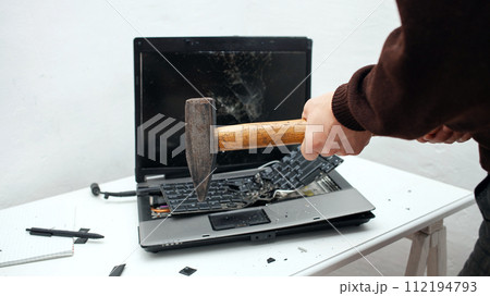 man destroyed laptop with a hammer. Nervous work, buggy computer, errors, slow Internet, not saved in the game, printed text, hung. Bad old computer failed, does not turn on, hangs. close up 112194793