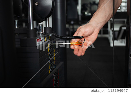 man exposes the weight on the simulator in the gym 112194947