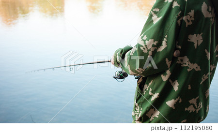 eldest on bank of river, a man with a fishing rod fishing, beautiful nature, autumn. An old man rests and loves his hobby. Active healthy lifestyle, outdoor. close up 112195080