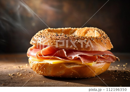 Sesame bun sandwich with prosciutto, cheese, lettuce, and tomato on orange background. Sesame bun sandwich with prosciutto, cheese, lettuce, and tomato on orange background. 112196350
