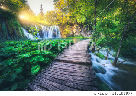 Waterfall and wooden path in green forest in Plitvice Lakes 112196977