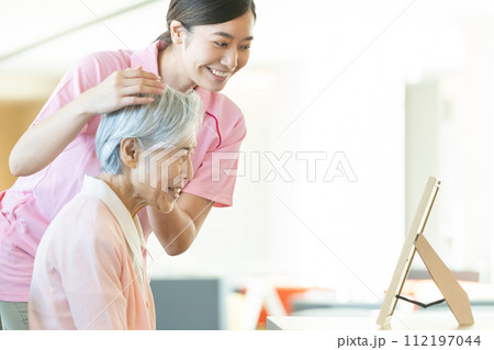 若い介護士とシニア女性 若い介護士とシニア女性 112197044