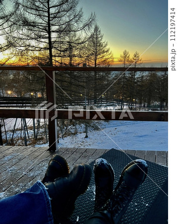 Winter landscape with snowy trees in the foreground and a bridge in the background 112197414