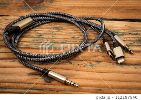 3 In 1 Type-C3.5mm Jack Aux Cable on a wooden texture background. Object 3 In 1 Type-C3.5mm Jack Aux Cable on a wooden texture background. Object 112197840