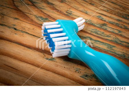 Denture toothbrush on a wooden background. Effective cleaning of teeth and gums Denture toothbrush on a wooden background. Effective cleaning of teeth and gums 112197843