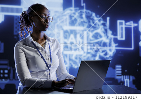BIPOC woman developing artificial intelligence neural networks nodes modeled after human brain. Tech support setting up AI machine learning accurately making predictions using data 112199317