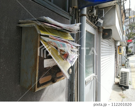 チラシで溢れかえった郵便受け 住居者不在の家 チラシで溢れかえった郵便受け 住居者不在の家 112201020