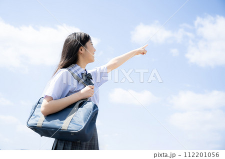 屋上の青空背景で夏期講習や受験などのイメージに使いやすい学生さん　指さし 112201056