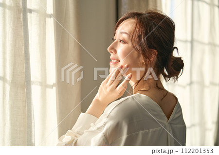 窓際で佇む女性 112201353