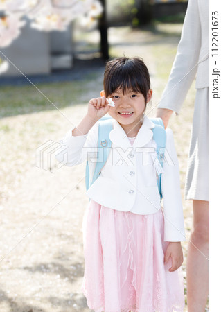 入学式シーズンとランドセルを背負った小学生の女の子 112201673