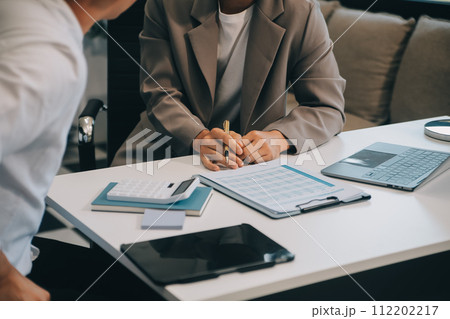 Business team working with new startup project plan and discussion information for financial strategy with laptop and digital tablet in a modern business lounge. 112202217