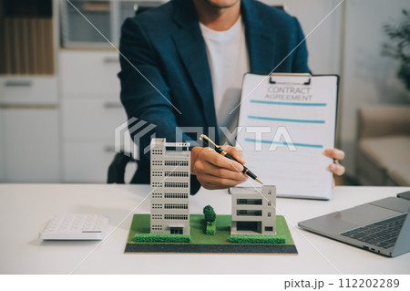 Real estate agent talked about the terms of the home purchase agreement and asked the customer to sign the documents to make the contract legally, Home sales and home insurance concept. 112202289