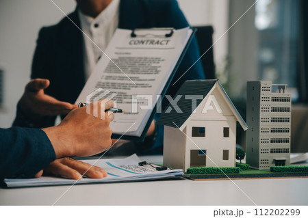 Real estate agent talked about the terms of the home purchase agreement and asked the customer to sign the documents to make the contract legally, Home sales and home insurance concept. 112202299