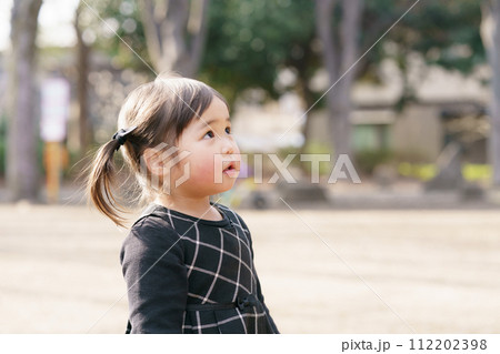 公園で遊ぶ小さな女の子 112202398