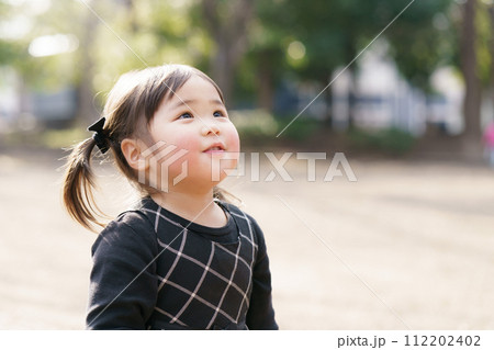 公園で遊ぶ小さな女の子 112202402