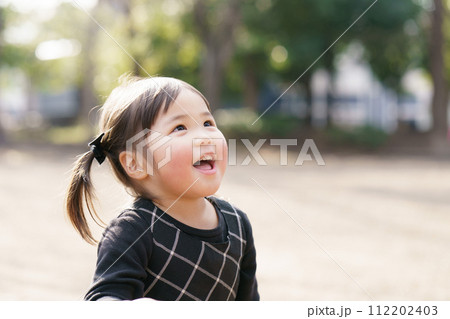 公園で遊ぶ小さな女の子 112202403
