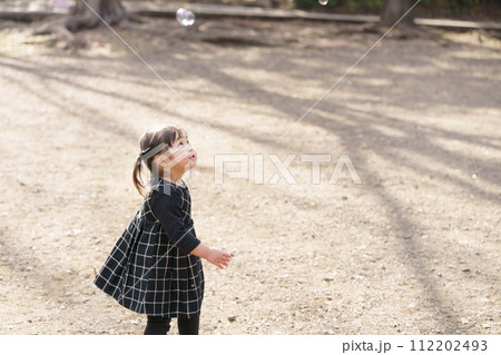 空を飛ぶシャボン玉を見上げる女の子 空を飛ぶシャボン玉を見上げる女の子 112202493