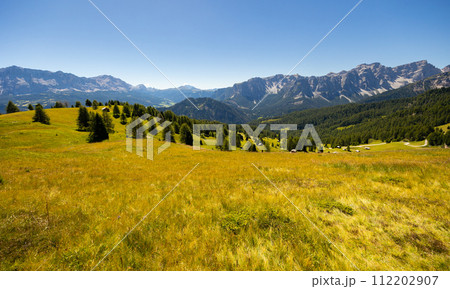 Craggy peaks of Italian Dolomites framed by greenery of meadows and forests Craggy peaks of Italian Dolomites framed by greenery of meadows and forests 112202907