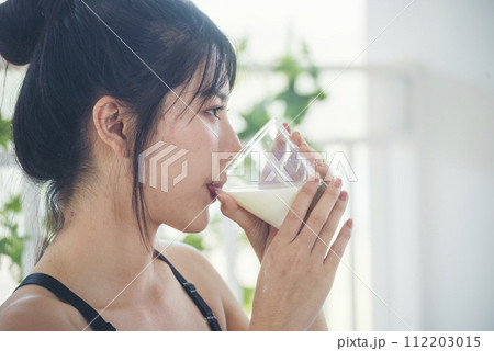 Asian women smile laugh look at camera health care home fitness lifestyle. Beautiful female drinking fresh milk low-fat dairy free lactose. Women hands holding white glass of milk pouring from bottle Asian women smile laugh look at camera health care home fitness lifestyle. Beautiful female drinking fresh milk low-fat dairy free lactose. Women hands holding white glass of milk pouring from bottle 112203015