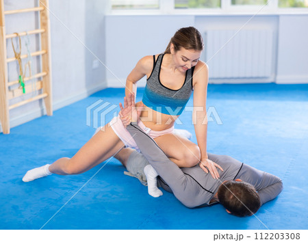 Young girl and middle-aged man practicing arm twist technique during self-defense courses Young girl and middle-aged man practicing arm twist technique during self-defense courses 112203308