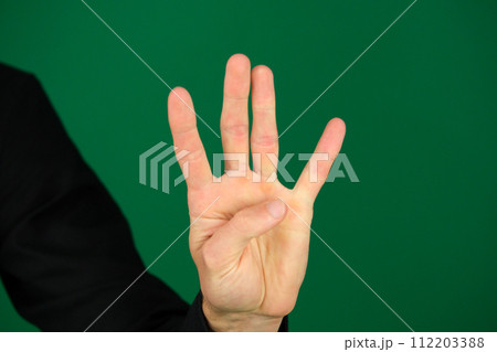 Mans hand isolated on a green background Mans hand isolated on a green background 112203388