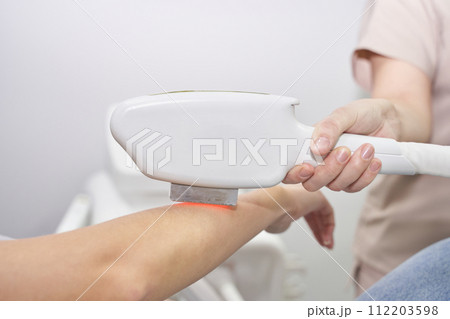 A woman undergoes laser hair removal treatment at a modern spa. Professional A woman undergoes laser hair removal treatment at a modern spa. Professional 112203598