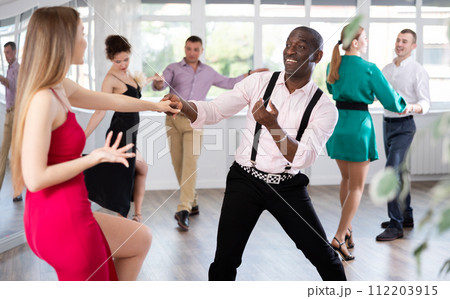 Woman dances incendiary boogie woogie with African man partner during choreography lesson Woman dances incendiary boogie woogie with African man partner during choreography lesson 112203915