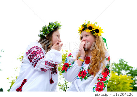 girls smiling having fun Ukrainian national costumes traditions girls resting in nature conversations gossip wreath of sunflowers and green grass with white flowers forest mavki beautiful women girls smiling having fun Ukrainian national costumes traditions girls resting in nature conversations gossip wreath of sunflowers and green grass with white flowers forest mavki beautiful women 112204126