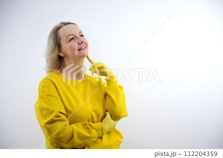 Photo of funny thoughtful young lady dressed yellow sweater arms cheekbones looking empty space isolated white color background 112204359