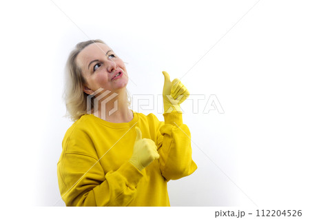 Smiling young redhead woman girl in casual yellow hoodie posing isolated on white background studio portrait. People sincere emotions lifestyle concept. Mock up copy space. Pointing thumbs on herself Smiling young redhead woman girl in casual yellow hoodie posing isolated on white background studio portrait. People sincere emotions lifestyle concept. Mock up copy space. Pointing thumbs on herself 112204526