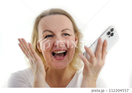 great happiness success joy close-up face of a woman laughing sincerely open her mouth looks to the side holds the phone in her hands raised her hands up on a white background 112204557