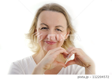 Happy millennial girl hold hands at heart chest feel thankful pray to God at workplace, calm peaceful young woman believer grateful for luck or fate, faith, superstition, gratitude concept 112204572