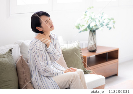 体調不良　頭痛で痛い頭をおさえるミドル女性 112206831