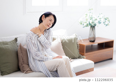 体調不良　頭痛で痛い頭をおさえるミドル女性 112206835