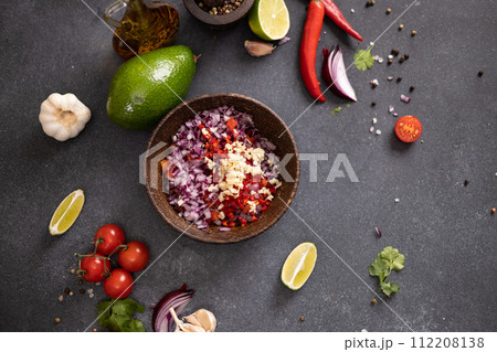 Cooking traditional salsa - sliced chopped ingredients in a wooden bowl 112208138