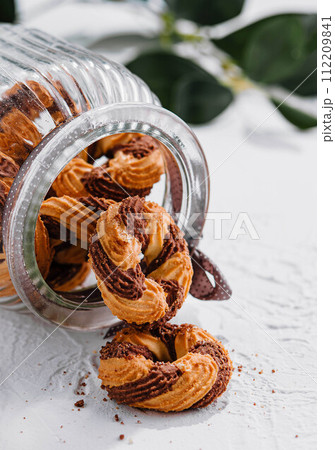 Chocolate cookies in a glass jar opened 112209841