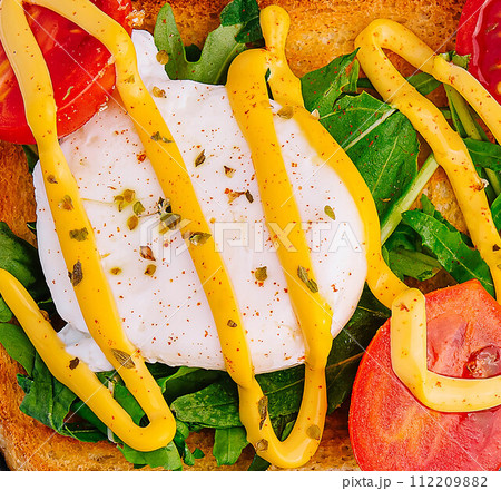 Poached egg with arugula, cherry tomatoes and toast Poached egg with arugula, cherry tomatoes and toast 112209882