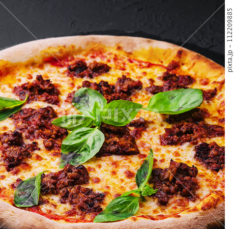 Pizza with minced meat and mozzarella on a stone board Pizza with minced meat and mozzarella on a stone board 112209885