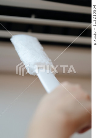 エアコンの吹き出し口を掃除する女性の手 112210804