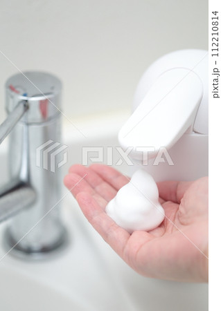 ハンドディスペンサーで手を洗う女性 112210814