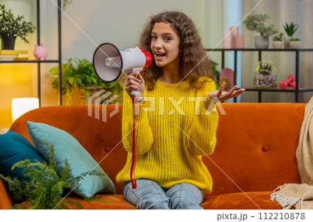 Teenager child girl kid talking with megaphone, proclaiming news, loudly announcing advertisement Teenager child girl kid talking with megaphone, proclaiming news, loudly announcing advertisement 112210878