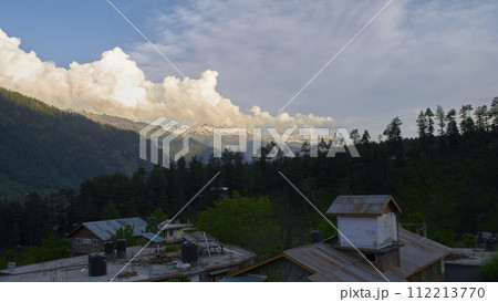 A vast landscape with clear skies, clouds, and snowy mountains. 112213770