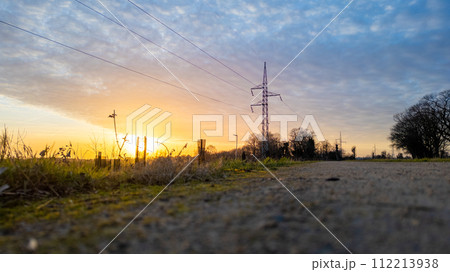 Sunset Glow behind Power Lines on a Country Road Sunset Glow behind Power Lines on a Country Road 112213938