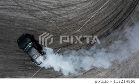 Aerial top view car drifting diffusion race drift car with lots of smoke from burning tires on speed track, Professional driver drifting car with lots of white smoke . 112214969